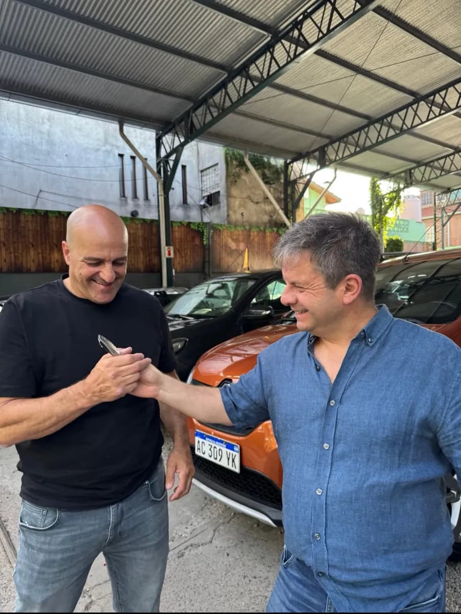 Un cliente recibe las llaves de su auto nuevo en el local