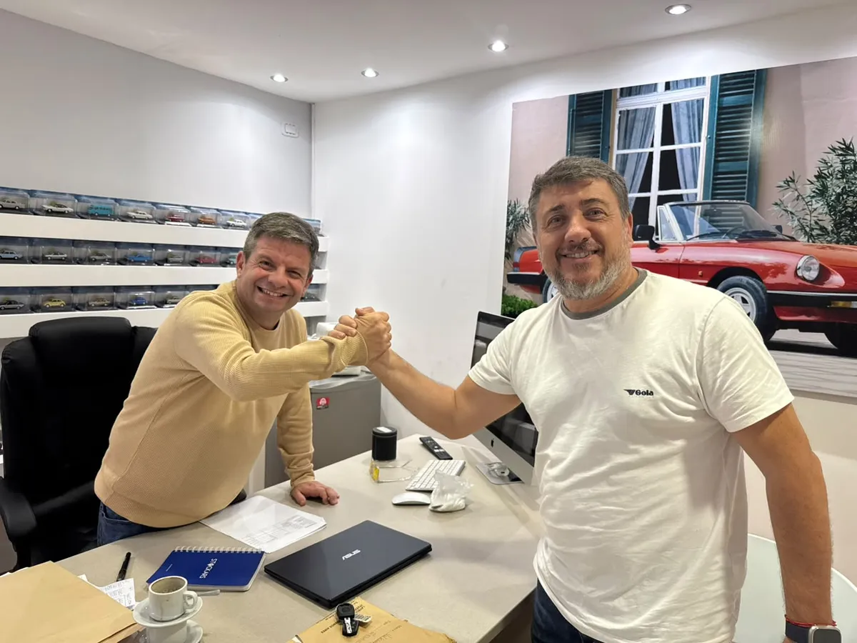 Juan Manuel y un cliente se dan la mano sobre el escritorio de la oficina